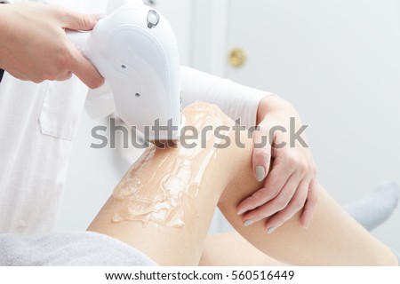 Beautician Giving Epilation Laser Treatment To Woman On Thigh Royalty-Free Stock Photo #560516449