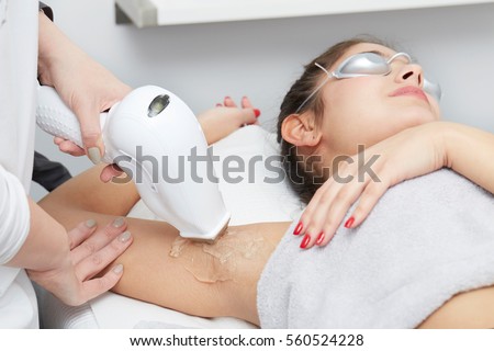 Beautician Giving Epilation Laser Treatment To Woman On underarm Royalty-Free Stock Photo #560524228