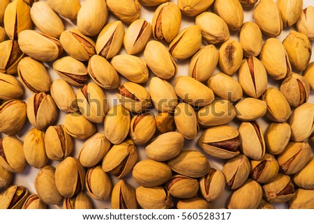 A lot of pistachios scattered everywhere creating a beautiful nuts food background.