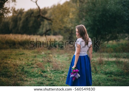 Romantic beautiful girl holding flowers in the forest
