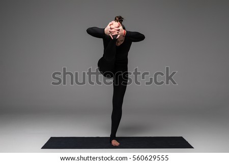 Utthita hasta. Beautiful yoga woman practice yoga poses on grey background. Yoga concept.