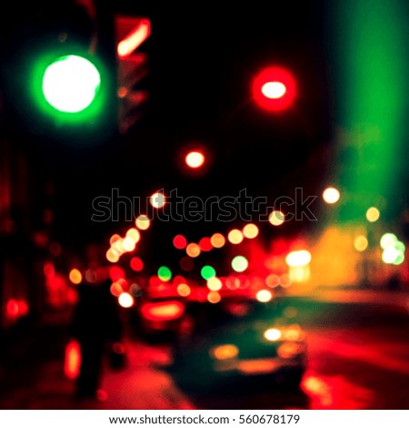 Abstract blurred red and green background with a street, road and car and traffic light