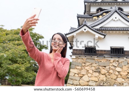 Woman taking selfie by mobile phone in Hikone Castle