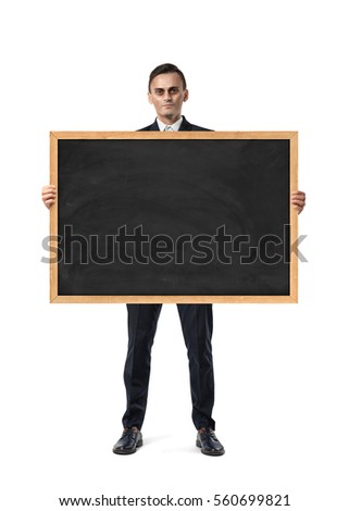 An upset businessman holds an empty blackboard isolated on the white background. Business defeat. Emotional state. Lack of fresh ideas.