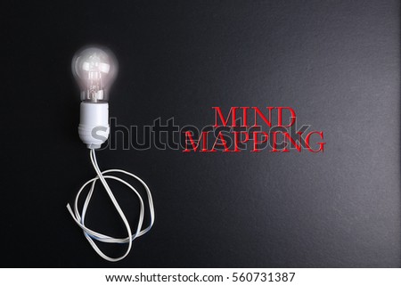 Bulb and black keyboard with innovation and strategic conceptual words. Low light