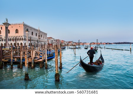 Venetian gondoliers await some tourists to carry around on a gondola in Venice Royalty-Free Stock Photo #560731681
