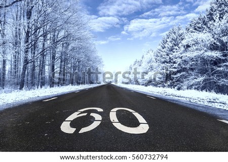 Winter black asphalt road with 60 sign on and beautiful frozen white ice winter landscape, Urk Flevoland Netherlands January 2017 , 60 concept road birthday 60 age postcard wallpaper art