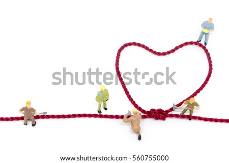 Miniature worker team building Heart Shaped with rope on white background 