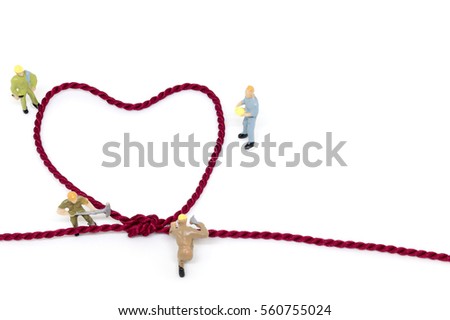 Miniature worker team building Heart Shaped with rope on white background 
