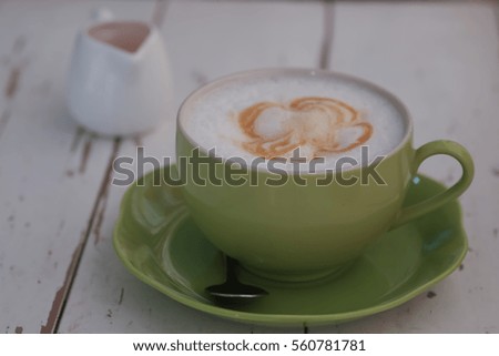 Cappuccino art coffee with caramel sauce on vintage wooden table 
