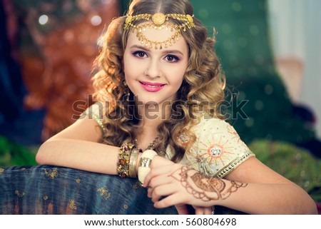 Portrait of a beautiful girl in Indian dress, with her hands painted with henna mehendi.