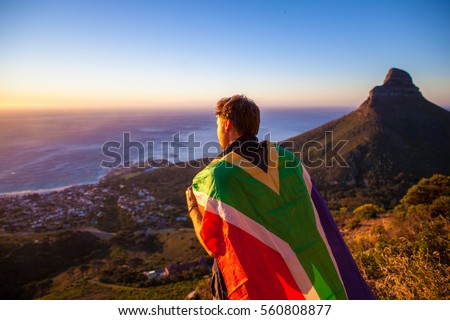 Man holding a south african flag over Cape Town Royalty-Free Stock Photo #560808877