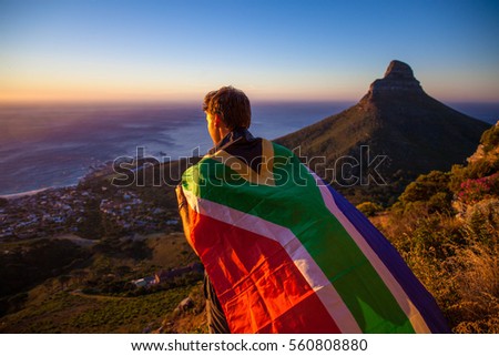 Man holding a south african flag over Cape Town Royalty-Free Stock Photo #560808880