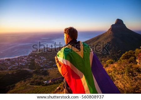 Man holding a south african flag over Cape Town Royalty-Free Stock Photo #560808937