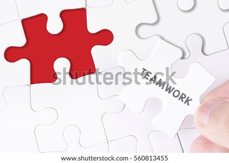 Female hand and missing puzzle with TEAMWORK WORD