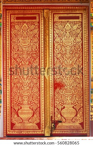 Gold color paint on red wooden door frame in flower and vase, lanna thai art pattern, northern thailand temple decoration style