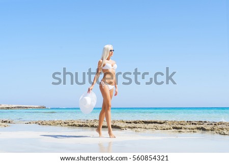 Beautiful woman in bikini. Young and sporty girl posing on a beach at summer.
