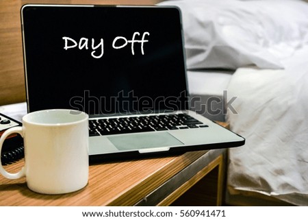 DAY OFF wording on laptop screen with bedroom interior background. Motivation and positive wishes office hour concept
