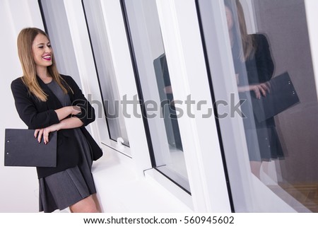 Beautiful business woman looking through her office window.