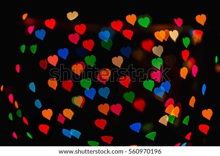 Bokeh blurred background of colored lights in the shape of heart.