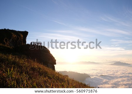 Silhouette peoples on top the mountain view point sunrise  and sea of mist, Thailand.