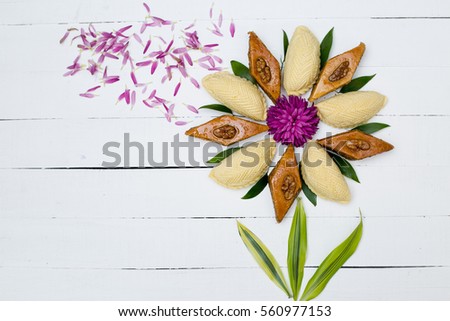 Flower made from national Azerbaijani Nowruz sweets pakhlava and shekerbura on white wooden background
