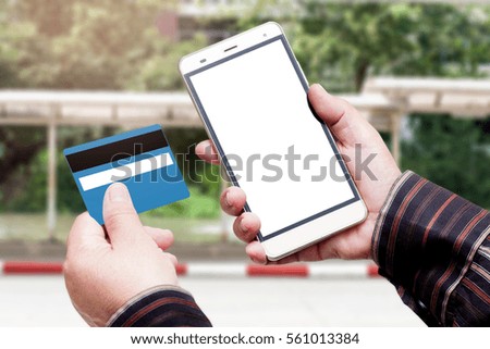 Hand Hold Smart phone with Credit Card over blurred of street