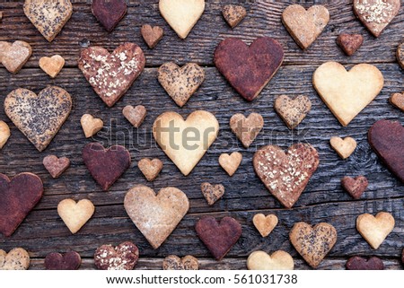 Delicious heart shaped cookies baked with love on wooden background