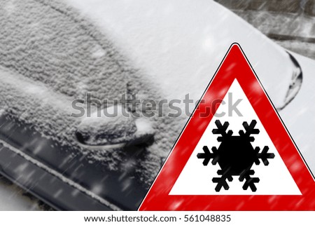 Snowed car and warning sign