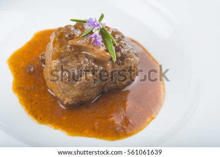 Oxtail stew served with its sauce and decorated with rosemary flowers