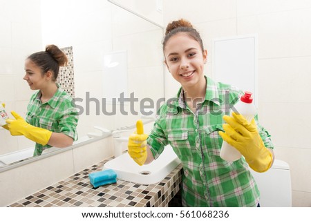housewife holding a detergent and showing thumbs up