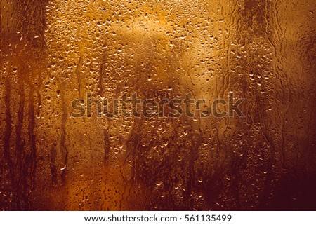 drops splatter on glass , the background a blurred window, evening mood