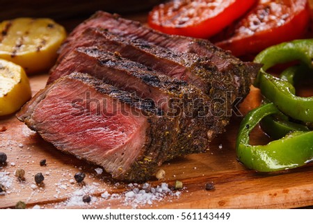 Juicy steak and grilled vegetables with spices Royalty-Free Stock Photo #561143449
