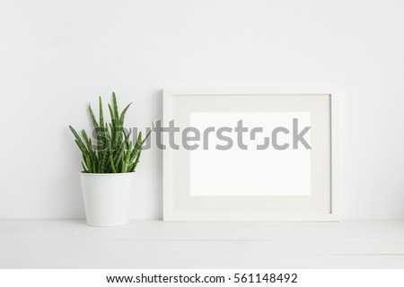 Mock up white frame and aloe vera plant on book shelf or desk. White colors.
