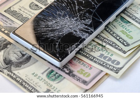 Smartphone with broken displayon money background. Loss of money concept