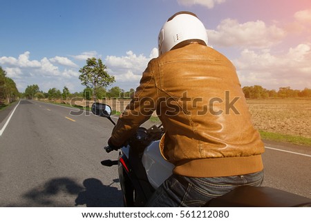Motorcycle drivers on road in summer day