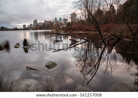 Long exposure landscape picture of the Lake (Lost Lagoon) in Stanley Park, Downtown Vancouver, BC, Canada. Taken during a cloudy winter sunrise.