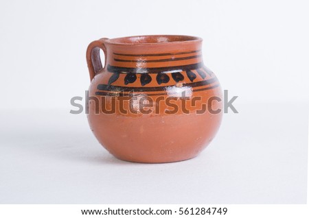 Mexican red clay jar, a cup of mexican sweet and hot coffee in a white background Royalty-Free Stock Photo #561284749