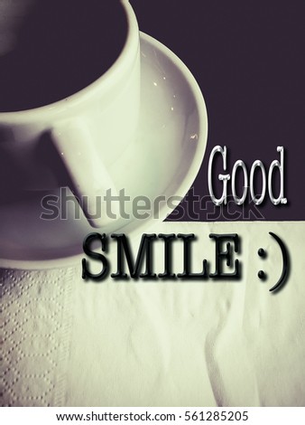 Words "Good SMILE :)" with a cup of coffee as a background.  Greetings, motivation, education and business concept.