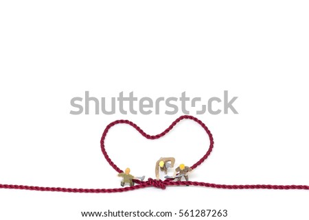 Miniature worker team building Heart Shaped with rope on white background 