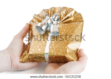 golden gift box with silver ribbon keeping in hands isolated on white background with clipping path
