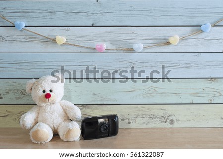Teddy bear with camera toys , background wood pastel color