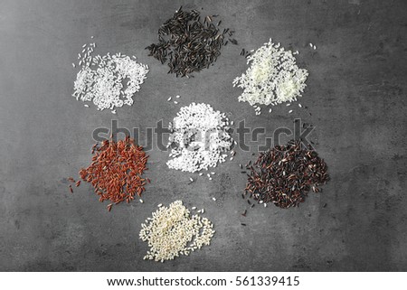 Different types of rice on grey textured background