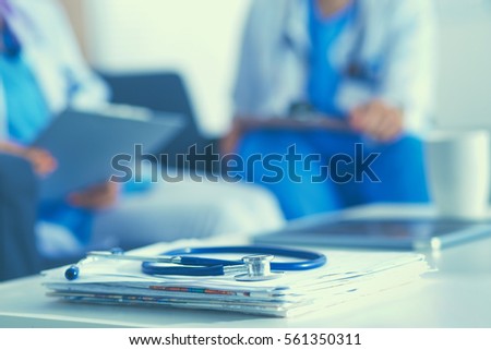 Happy medical team discussing and working together Royalty-Free Stock Photo #561350311