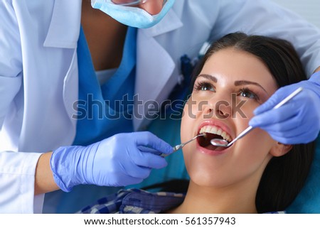 Woman dentist working at her patients teeth Royalty-Free Stock Photo #561357943