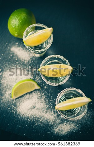 Silver Mexican tequila with lime and salt, toned picture, selective focus, close up, top view