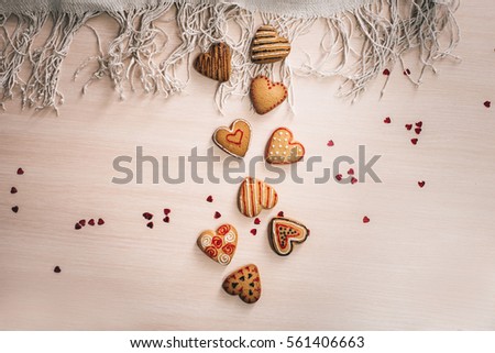 Heart shaped cookies with a colored pattern on the wooden light background, decoration for Valentine's Day. souvenir card
