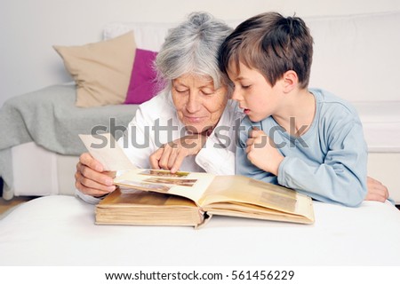 Grandmother and grandson are looking at an photograph album together