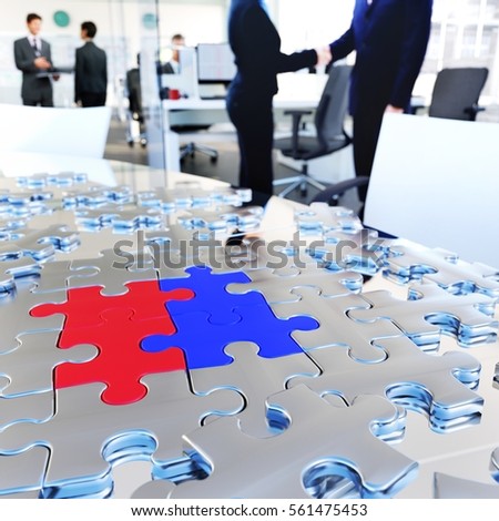 Conceptual business image. Puzzle pieces on meeting table at busy modern office.