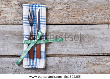 Utensils with wooden handles. Green ribbon bow and cutlery. Useful and elegant gift.